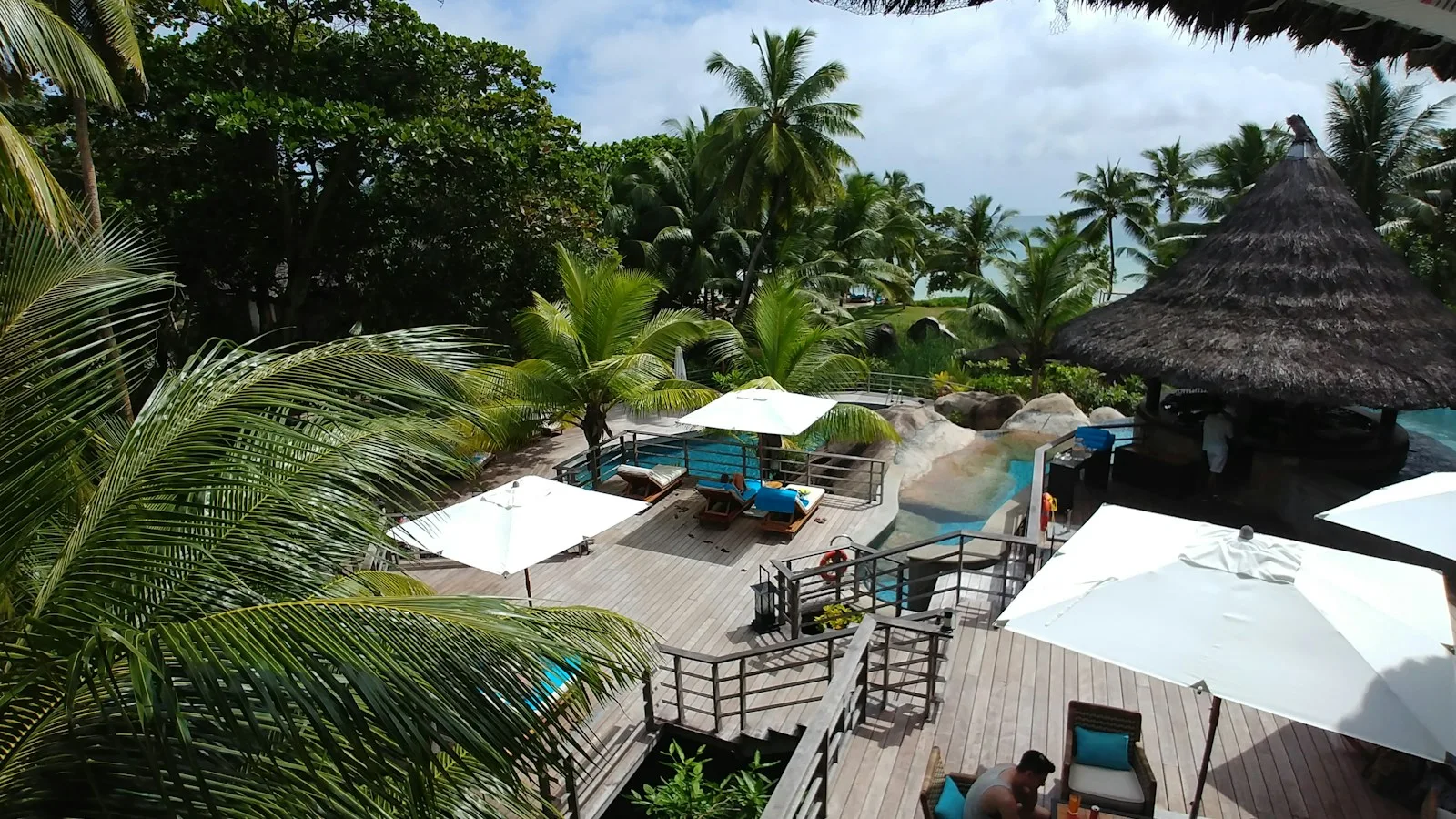 Bouteille de bière locale et verre de rhum sur une table face à une plage de granit aux Seychelles